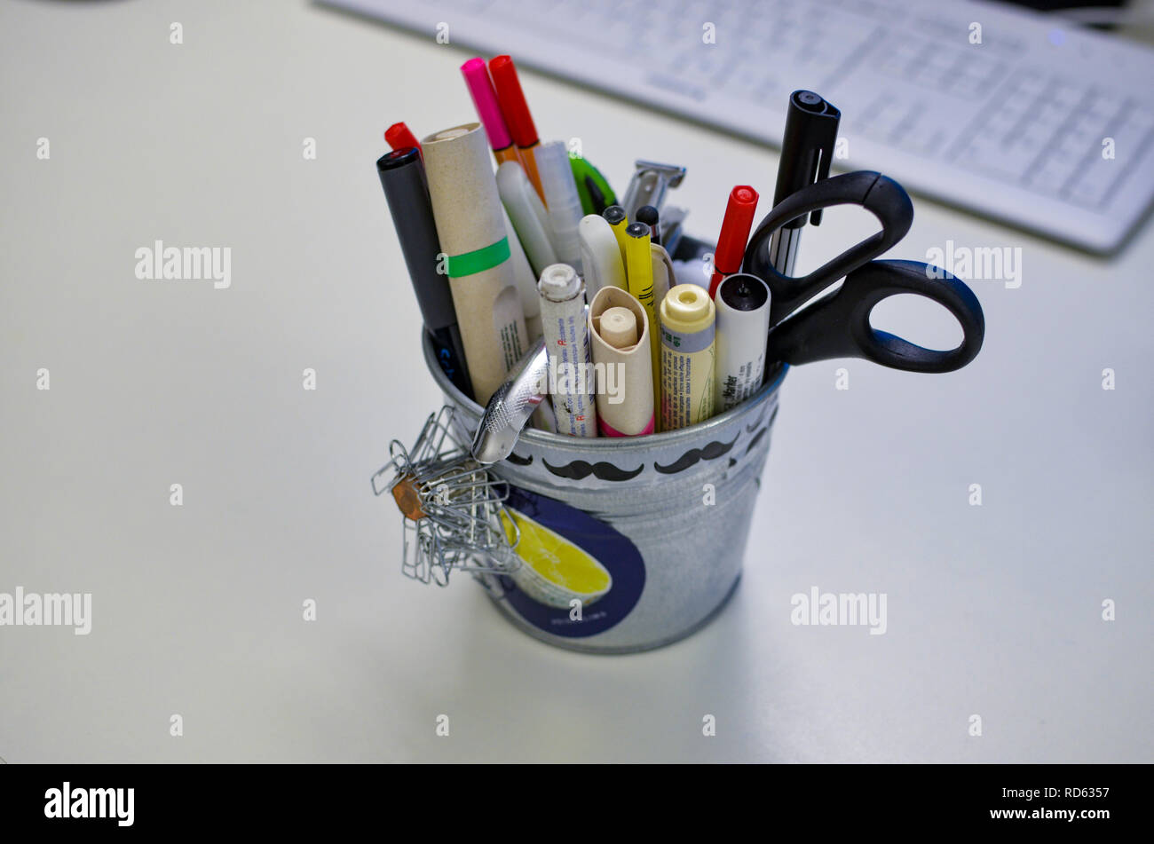 Portamatite con penne, pennarelli e forbici su una scrivania bianca Foto  stock - Alamy