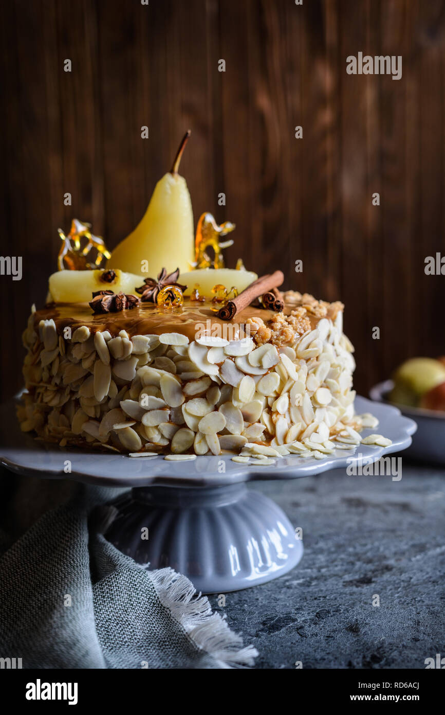 Una deliziosa torta a strati con glassa al caramello, decorata con mandorle  a fette, pere, spun decorazioni di zucchero e bastoncini di cannella Foto  stock - Alamy