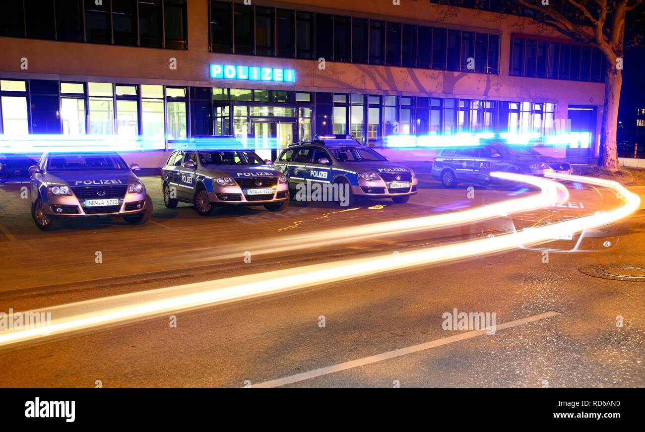 Auto della polizia guida off con luci lampeggianti, pattuglia delle vetture parcheggiate nella parte anteriore di una moderna stazione di polizia, Gelsenkirchen Foto Stock