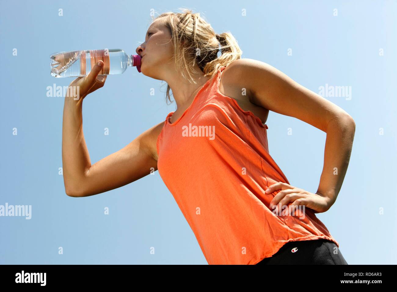 Giovane donna, 25-30 anni, bere da una bottiglia di acqua dopo esercizio Foto Stock