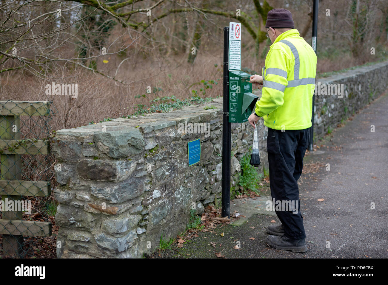 Lavoratore del consiglio a Mutt Mitt punto per i sacchi degradabili dei rifiuti del cane a Killarney, contea di Kerry, Irlanda. Dispenser MITT mutt. Foto Stock