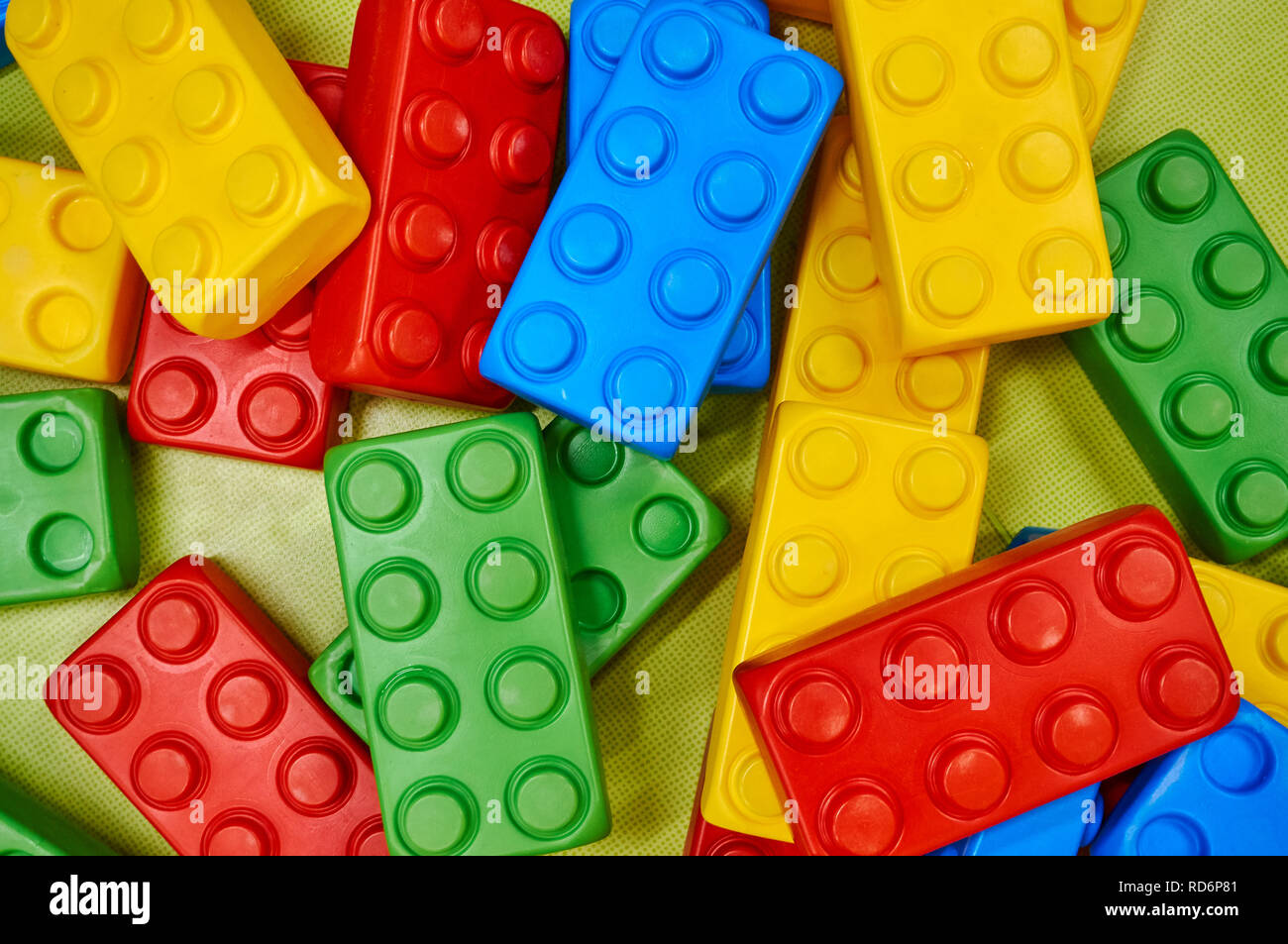Oversized per bambini in plastica colorata costruzione di blocchi sparsi sul pavimento. Foto Stock