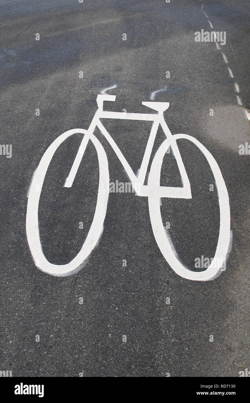 Verniciato bianco bicicletta stilizzata simbolo su un lastricato pista ciclabile accanto ad una strada principale in British Columbia, Canada. Foto Stock