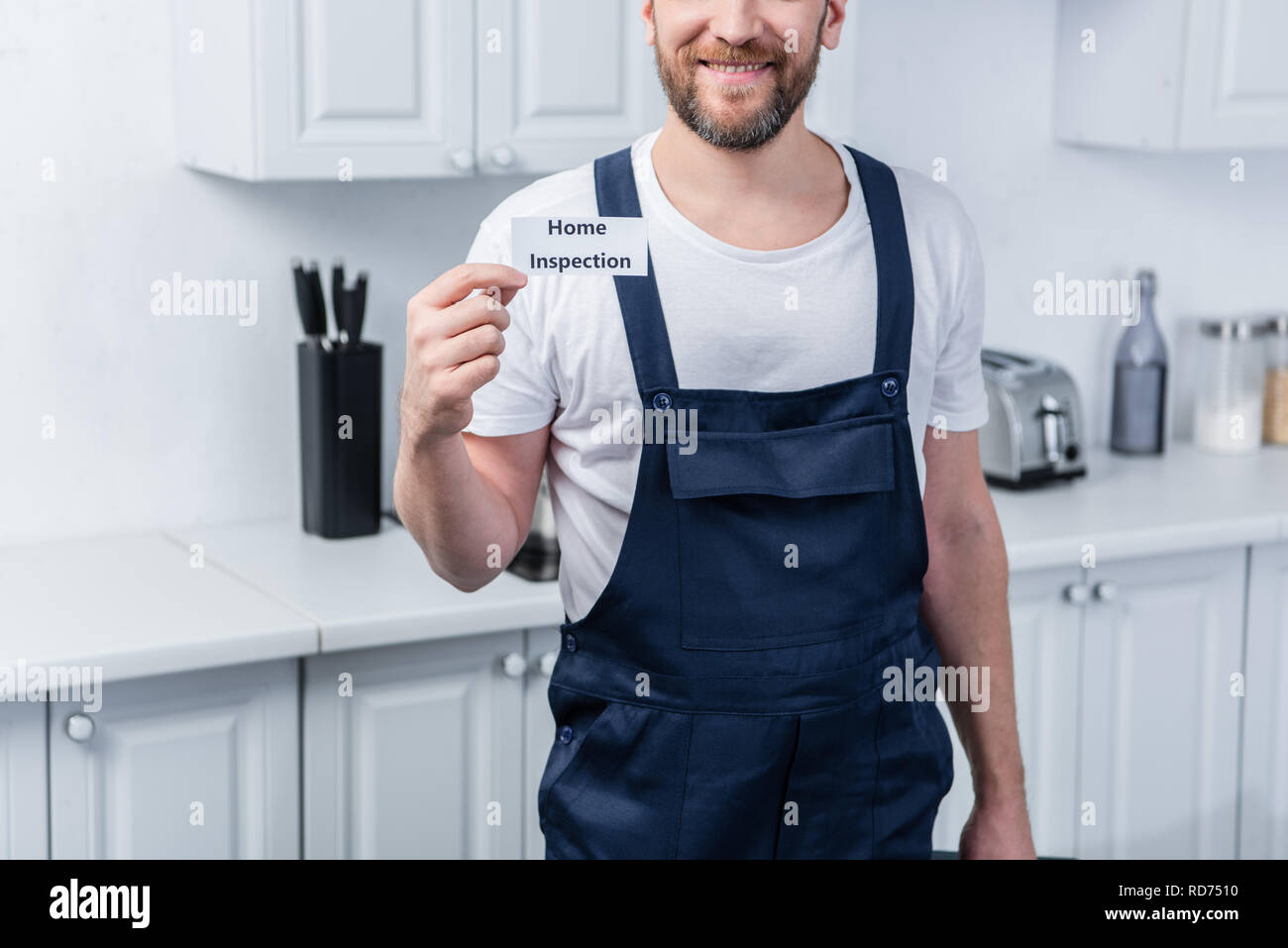 Ritagliato shot di maschio tuttofare holding toolbox e mostra la scheda con scritte di ispezione iniziale Foto Stock