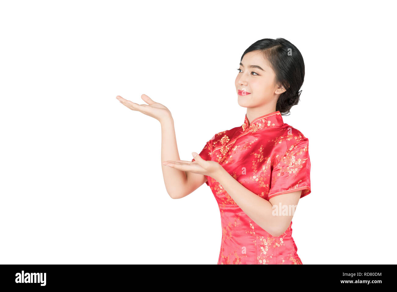 Bella femmina asiatica cinese con abito tradizionale cheongsam o qipao mano che mostra lo spazio vuoto. Anno Nuovo Cinese concetto, modello femminile isolati su whi Foto Stock