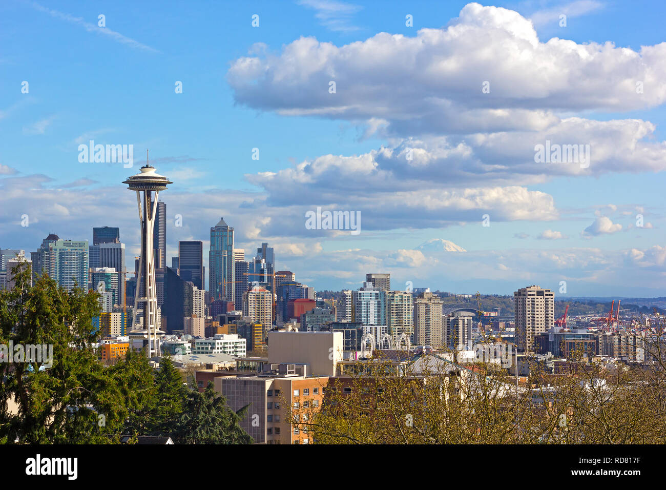 Urban panorama di Seattle e il picco caratteristico del monte Rainier sopra le nubi all'orizzonte. Foto Stock