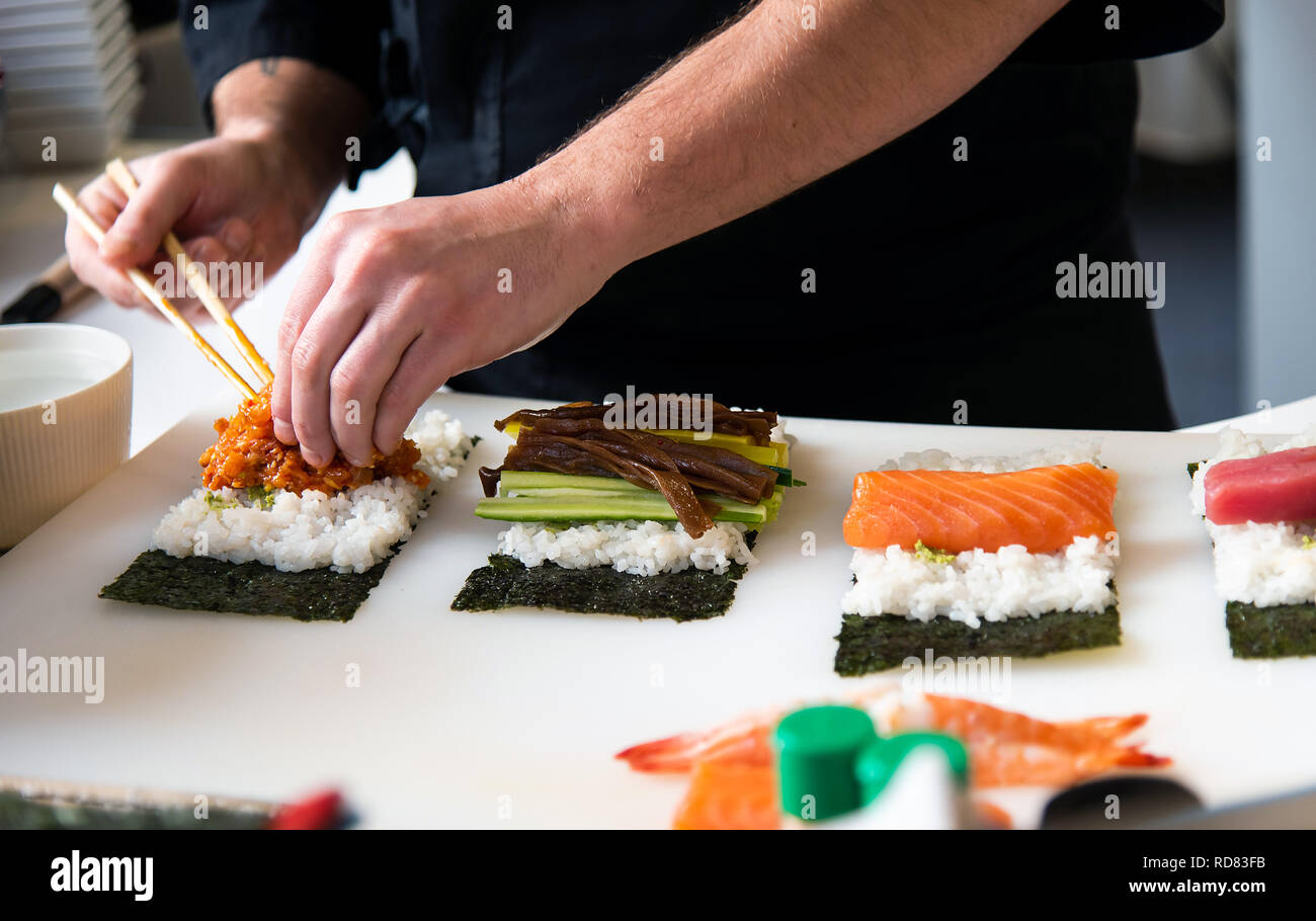 Lo Chef effettua il sushi nel bar vicino fino Foto Stock