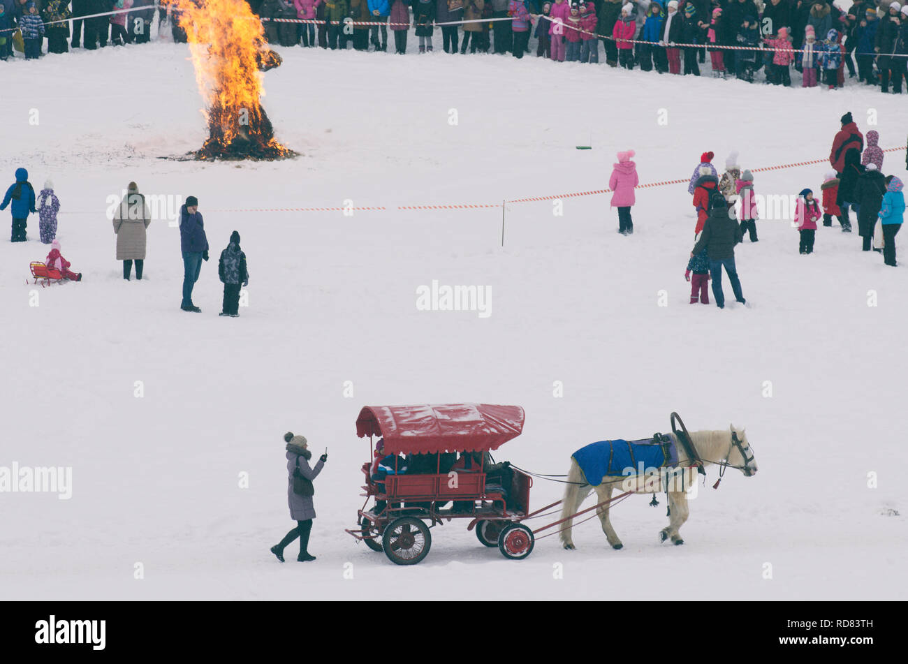 San Pietroburgo , Russia - 17 Febbraio 2018: Russo Maslenitsa vacanze. Masterizzazione effigie di paglia e un cavallo con un carrello in primo piano. Foto Stock