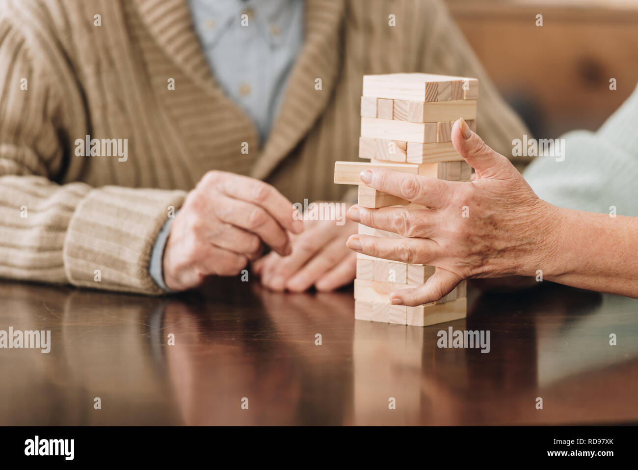 Vista ritagliata della coppia senior giocando jenga a casa Foto Stock
