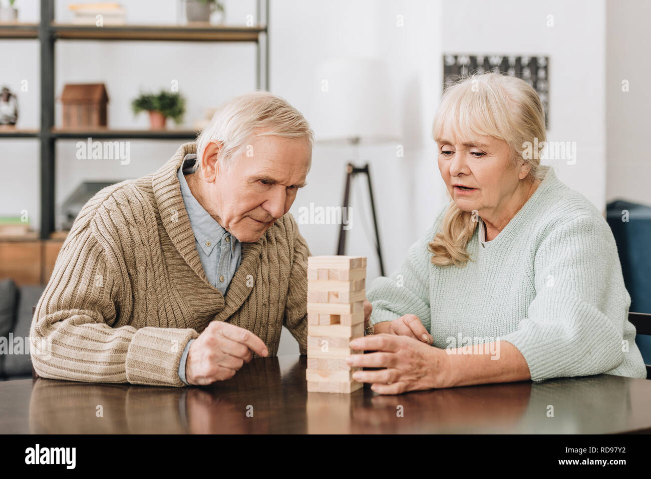 Coppia senior giocando con dei blocchi di legno a casa Foto Stock