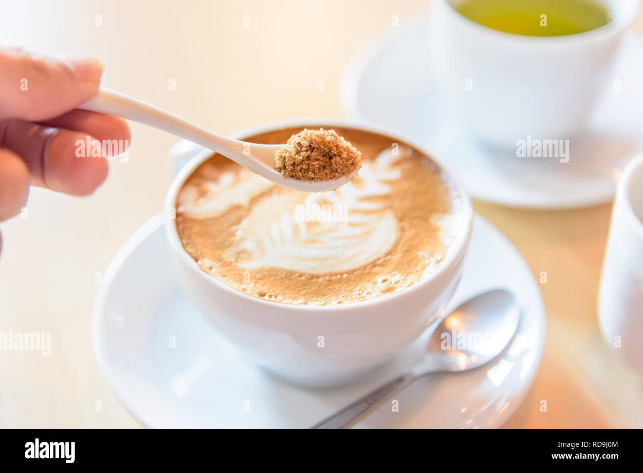 Aggiungere lo zucchero di caffè caldo Foto Stock