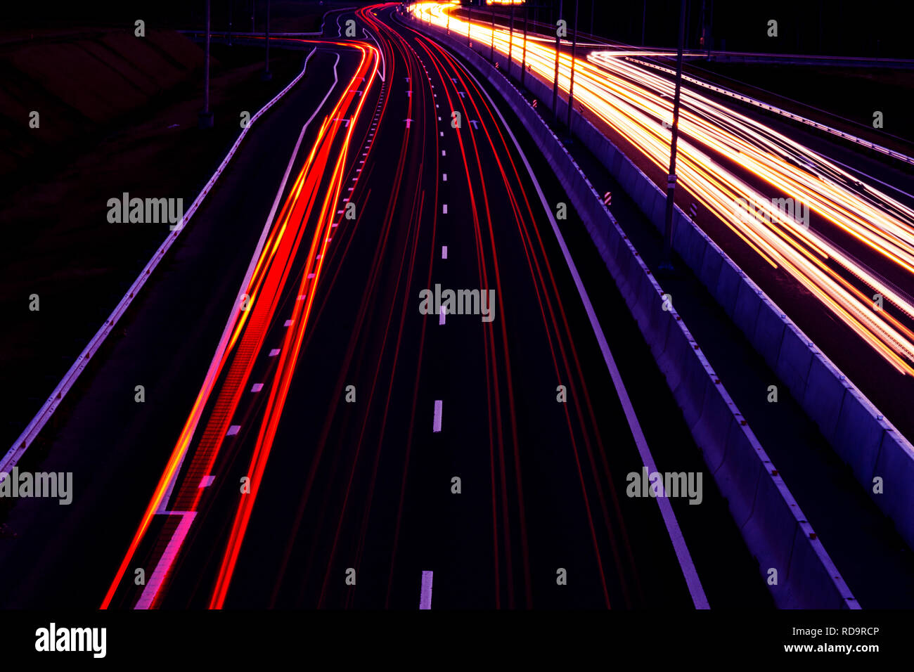 Auto sentieri di luce su di una curva autostrada di notte. Il traffico di notte sentieri. Motion Blur. Notte city road con traffico moto faro. Paesaggio urbano. Si accendono Foto Stock
