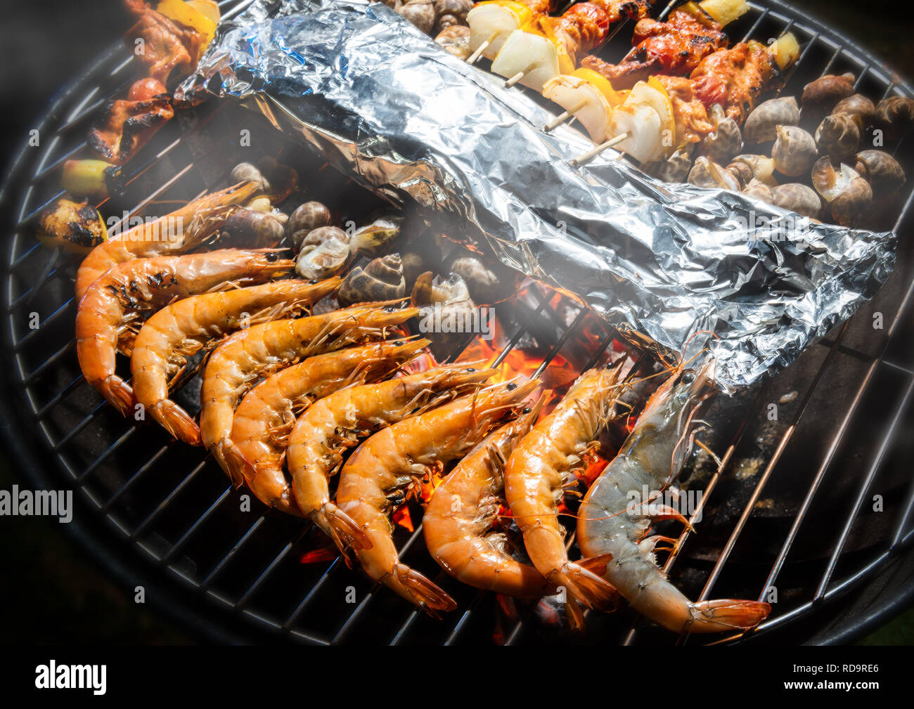 Grigliata di fuoco di fiamma a base di pesce e cibi barbecue. Foto Stock