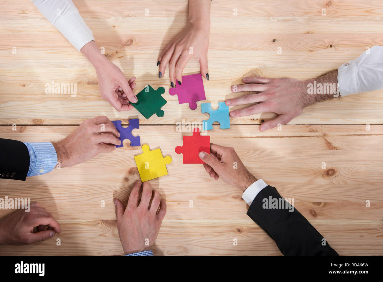 La gente di affari unire i pezzi del puzzle in ufficio. Concetto di partnership e il lavoro di squadra Foto Stock
