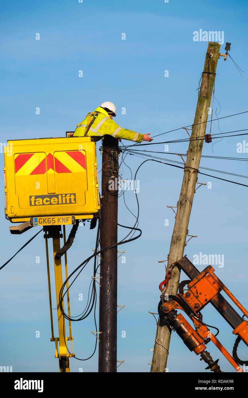 Infrastruttura di telecomunicazioni nel Regno Unito : appaltatori, utilizzando un cherry picker piattaforma sopraelevata, lavorare in altezza, la sostituzione di un palo del telegrafo e linee telefoniche per BT British Telecom in una posizione rurale, Borth , Wales UK Foto Stock