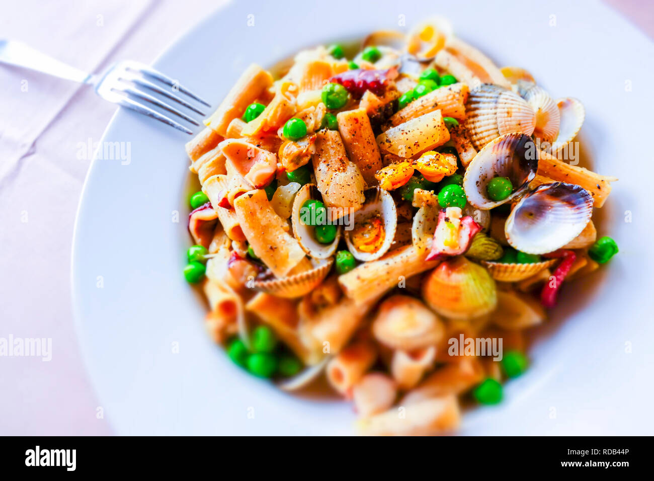 Pasta integrale con le vongole, piselli e polpi. Foto Stock