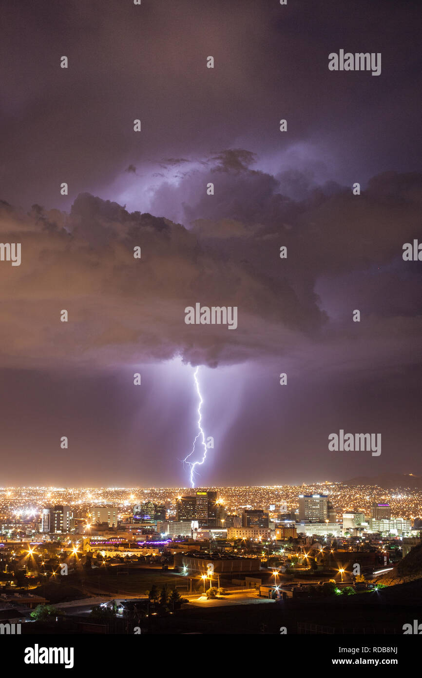 Il fulmine colpisce il paesaggio urbano dietro il centro di El Paso, Texas skyline in una calda notte d'estate vicino a noi a bordo del Messico Foto Stock