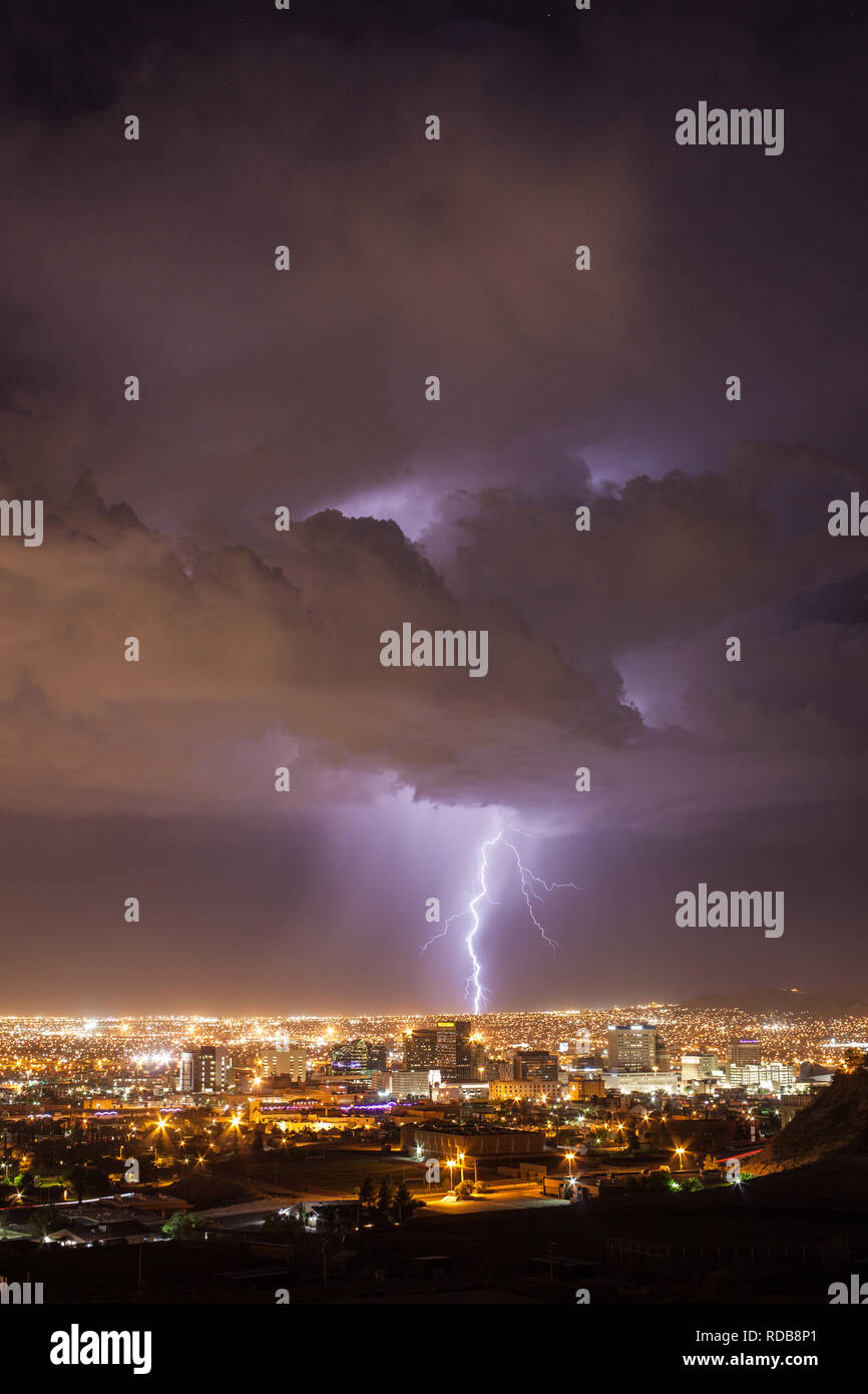 Il fulmine colpisce il paesaggio urbano dietro il centro di El Paso, Texas skyline in una calda notte d'estate vicino a noi a bordo del Messico Foto Stock