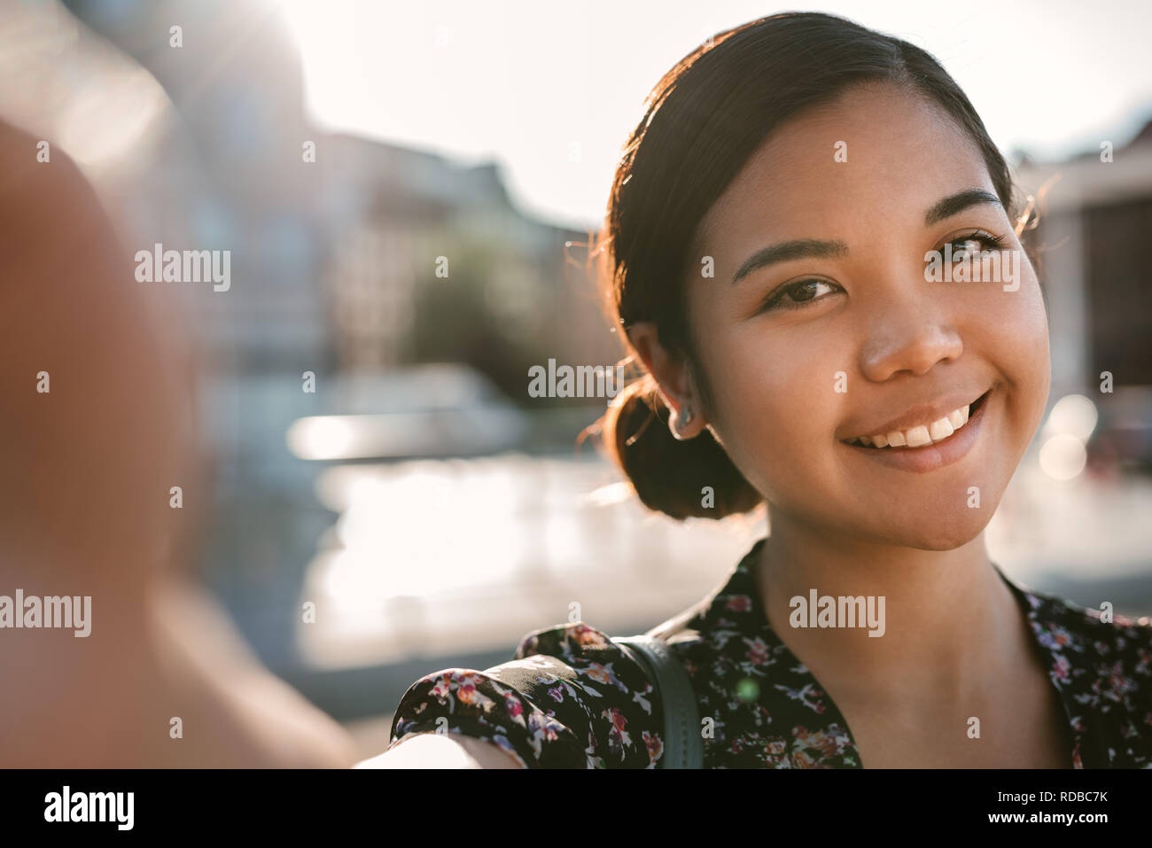 Sorridente giovani asiatici studente di college in piedi al di fuori prendendo un selfie Foto Stock