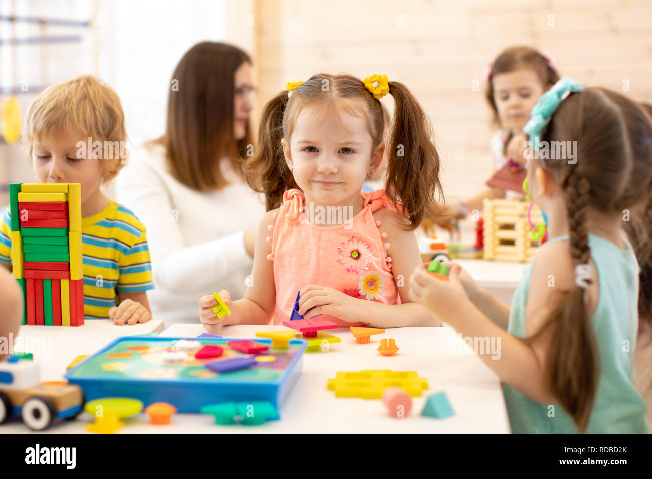 Gruppo di bambini in età prescolare giocando con colorati giocattoli didattici al kindergarten Foto Stock