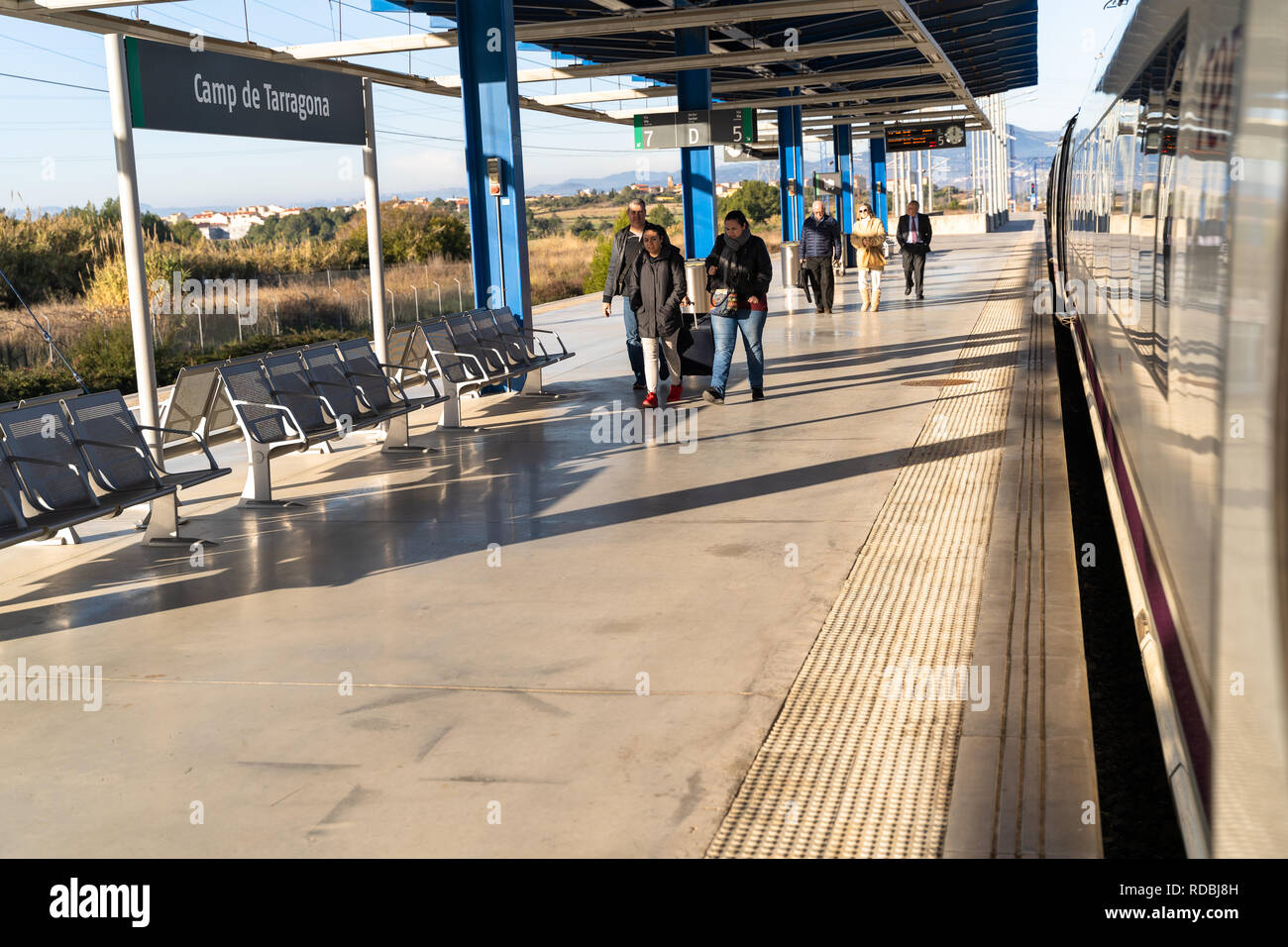 Treno ad alta velocità AVE parcheggiato sulla piattaforma di Camp de Tarragona stazione e i viaggiatori con le valigie lasciando alla stazione. Tarragona, Spagna Foto Stock