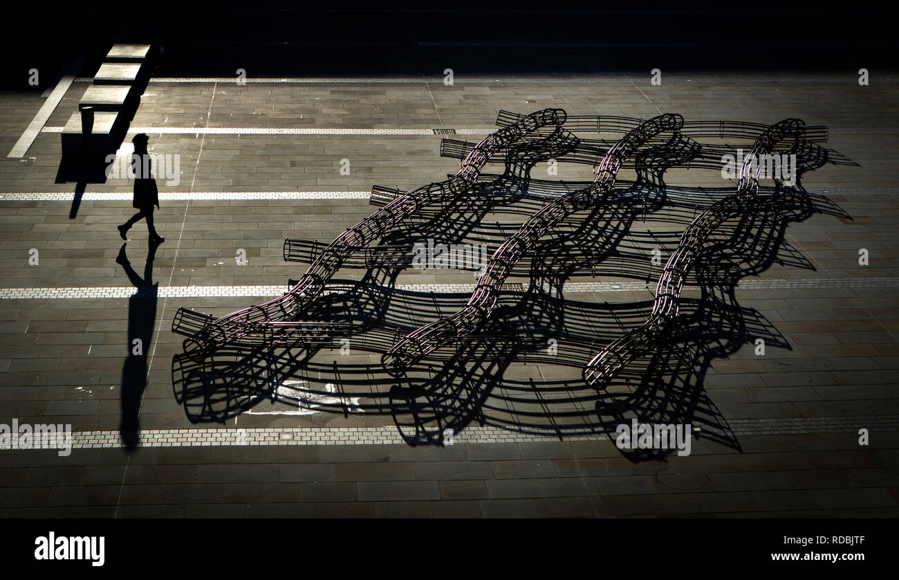 Un membro del pubblico getta un ombra come lei cammina in passato la coperta dallo scultore David Murphy come l'opera d'arte è svelata al pezzo Hall di Halifax - un grado 1 edificio risalente al 1779 che è stato un centro globale per i prodotti tessili. Foto Stock