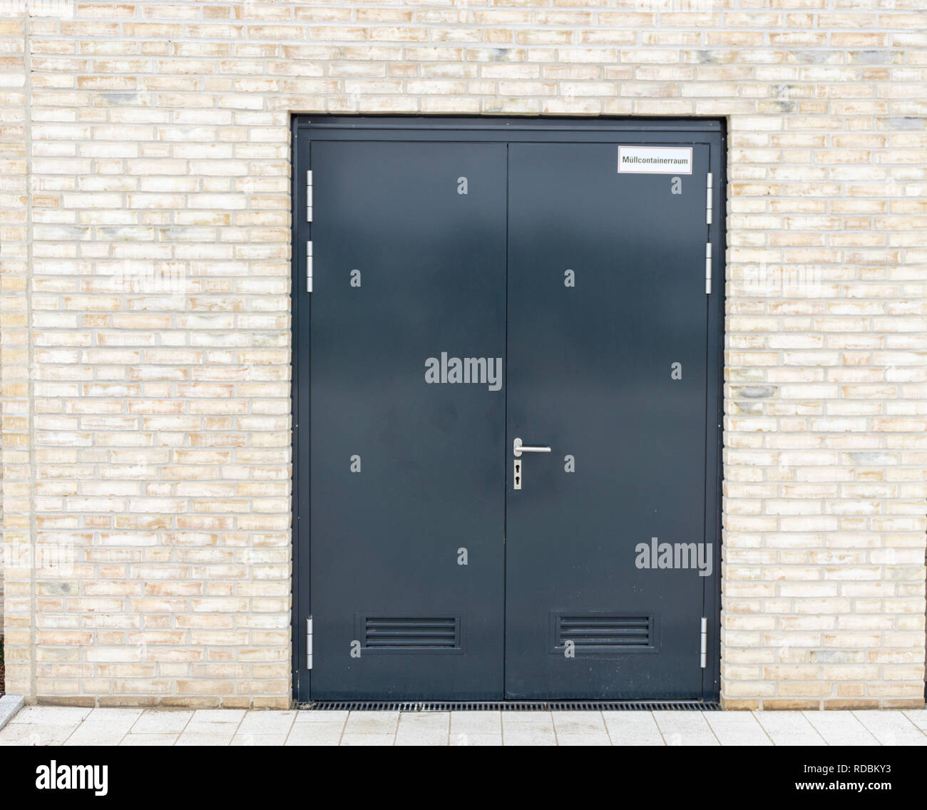 Dark Porta moderna in una luminosa parete di mattoni Foto Stock