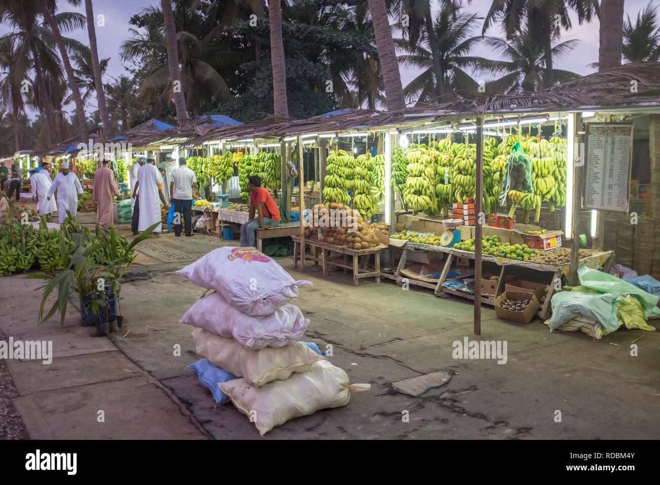 Strada bancarelle che vendono frutti come banane, noci di cocco e di ananassi in Salalah, provincia di Dhofar, Oman Foto Stock