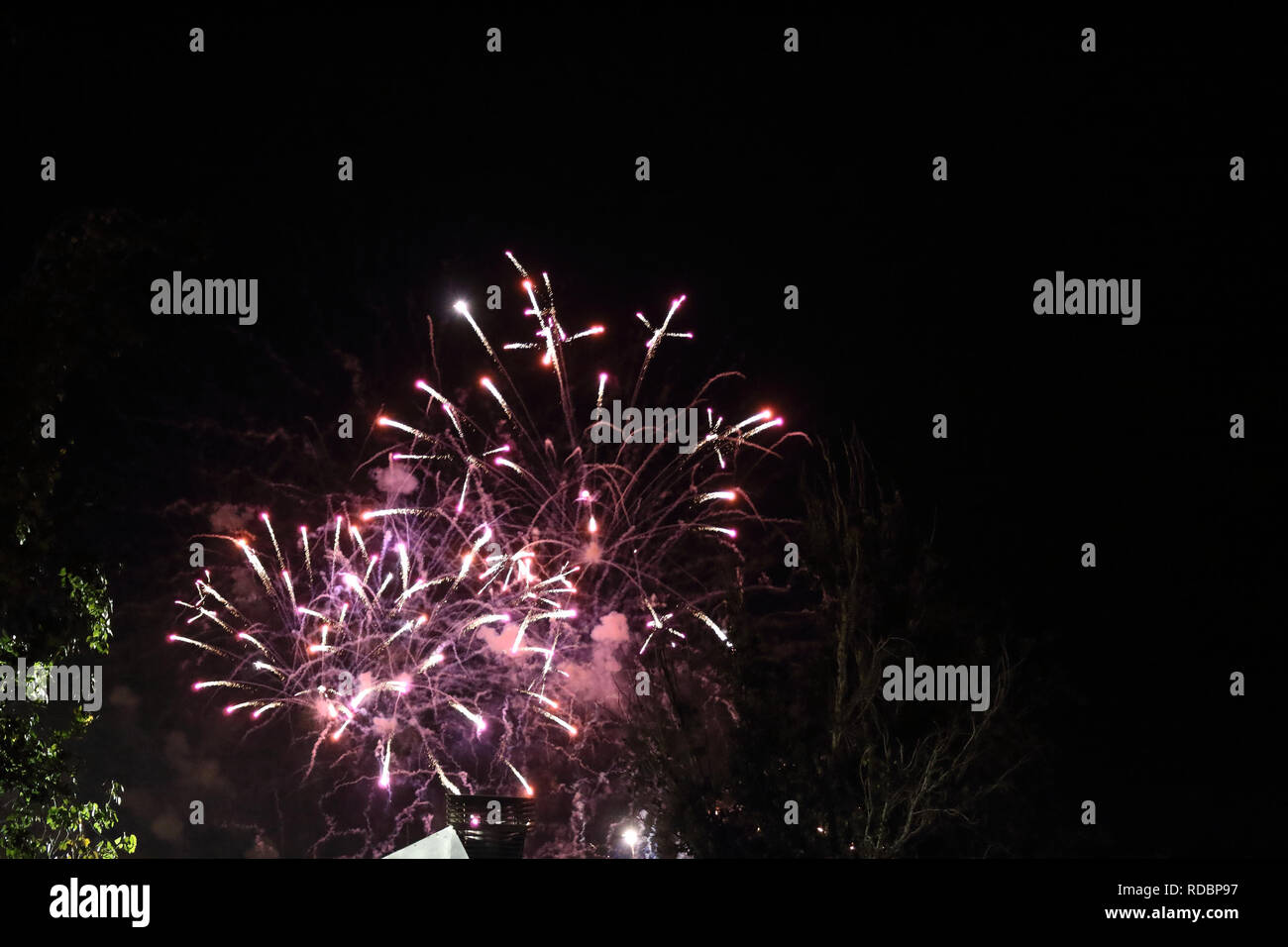 La frizzante e luminosa fuochi d'artificio durante il 2017 festival di Pilar contro un cielo scuro a Saragozza, regione di Aragona, Spagna Foto Stock