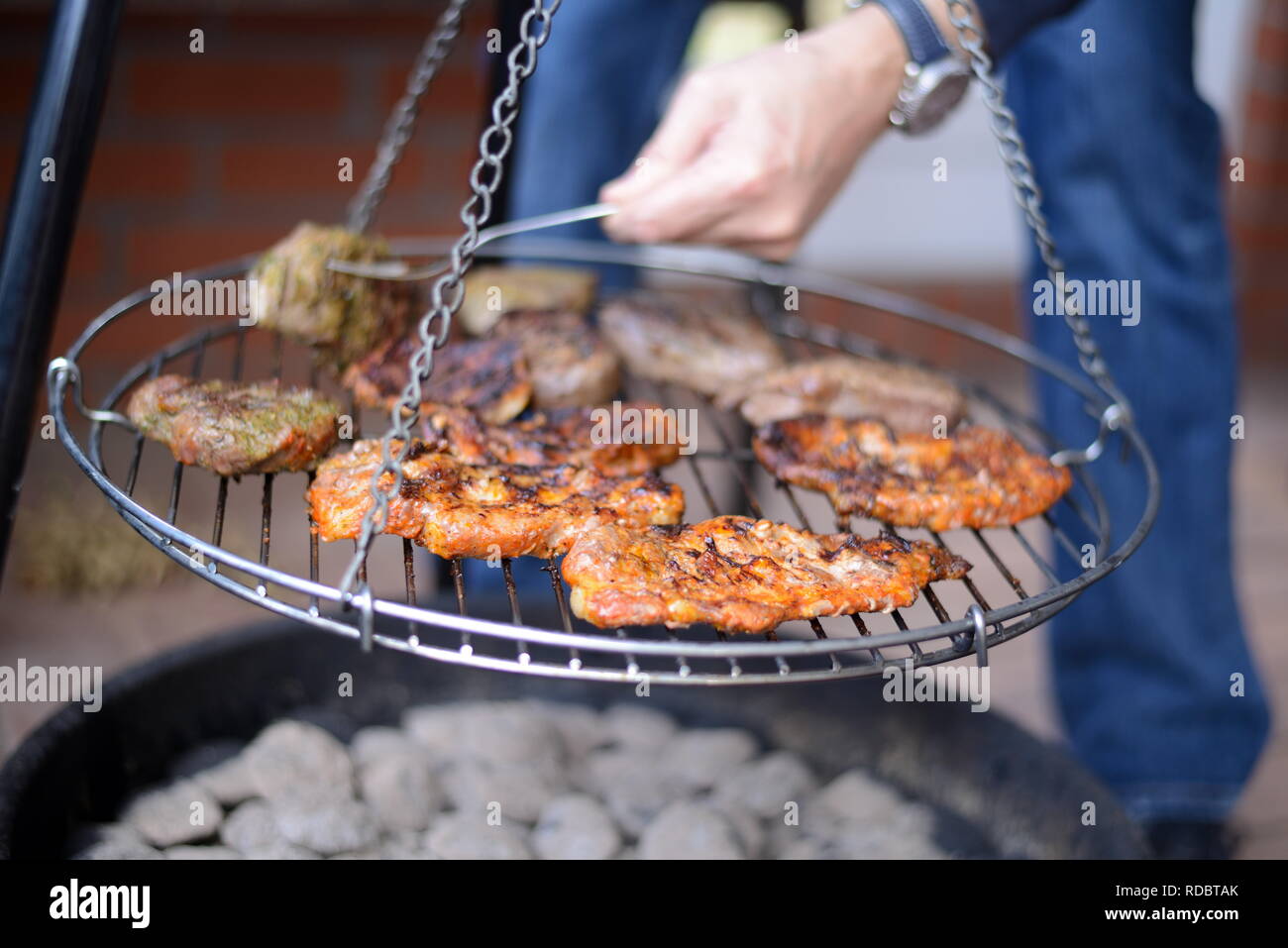 Lecker Rinder Steak und ungesundes Schweinefleisch grillen über Grillkohle auf der Gartenparty, heißes Grillfleisch von modernem Lagerfeuer Foto Stock