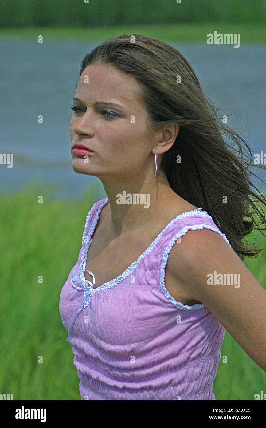 Bella bruna donna in un serbatoio di rosa e superiore blu jean pantaloncini corti Foto Stock Bella bruna donna in un serbatoio di rosa e superiore blu jean pantaloncini corti Foto Stock