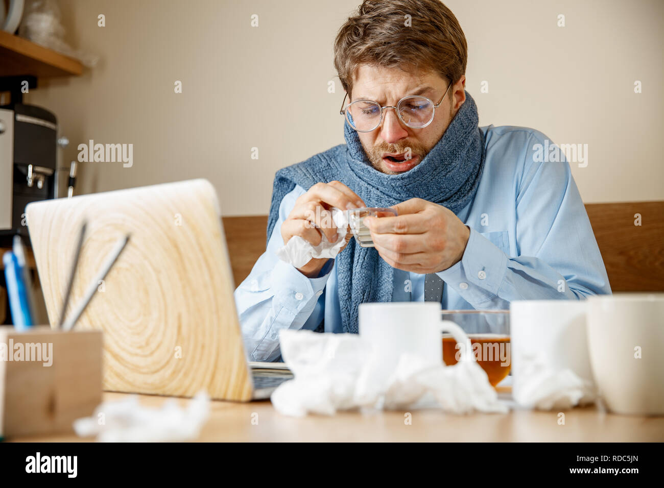 Uomo malato con le pillole che lavorano in ufficio, imprenditore catturati freddo, l'influenza stagionale. Pandemia di influenza, la prevenzione delle malattie, la malattia, virus, infezione, temperatura, febbre e concetto di influenza Foto Stock