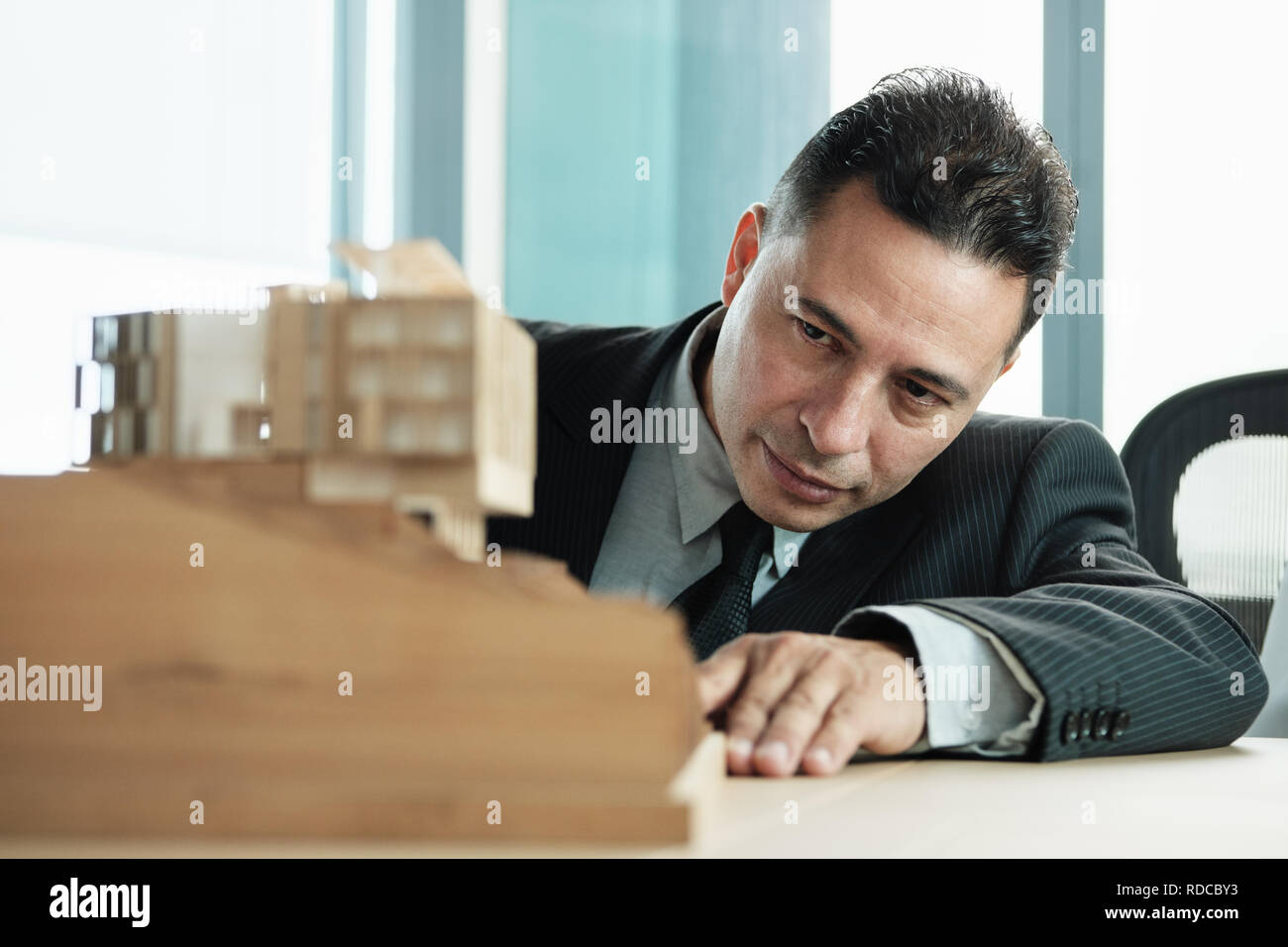 Imprenditore fiducioso guardando in miniatura di architettura Progetto di casa Foto Stock