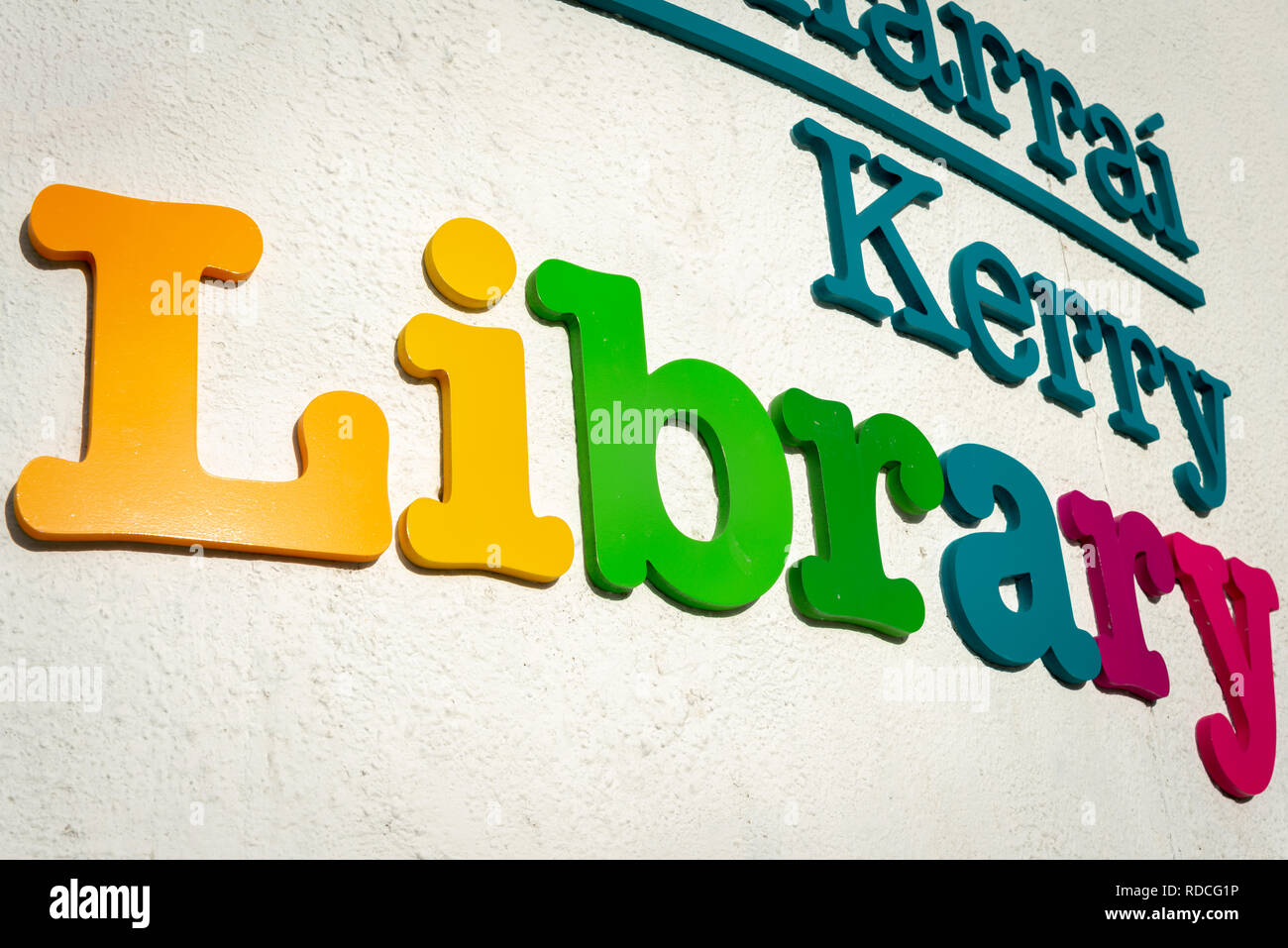 Logo e cartello della biblioteca Kerry, Killarney, County Kerry, Irlanda. Lettere multicolore su parete bianca. Concetto di istruzione. Foto Stock