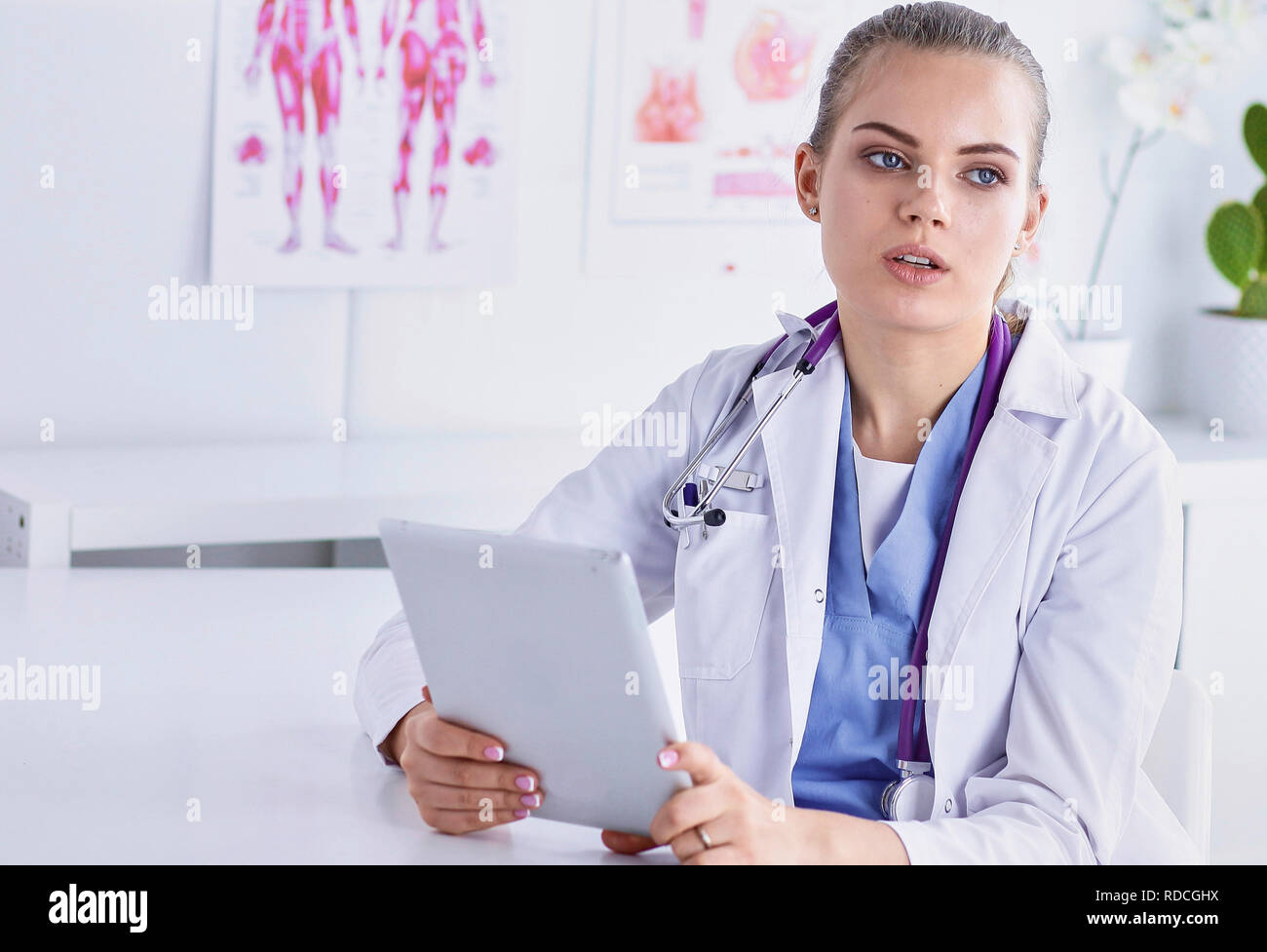 Un giovane medico donna a una scrivania in ufficio. Il concetto di h Foto Stock