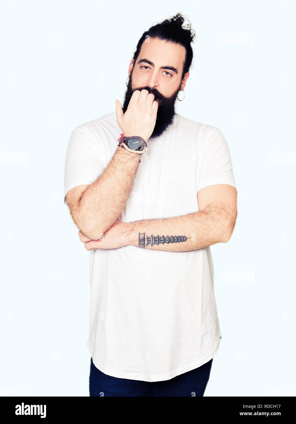 Tanga giovane uomo con i capelli lunghi e la barba che indossa casual t-shirt bianco cercando stressato e nervoso con le mani sulla bocca di mordere le unghie. Problema di ansia Foto Stock