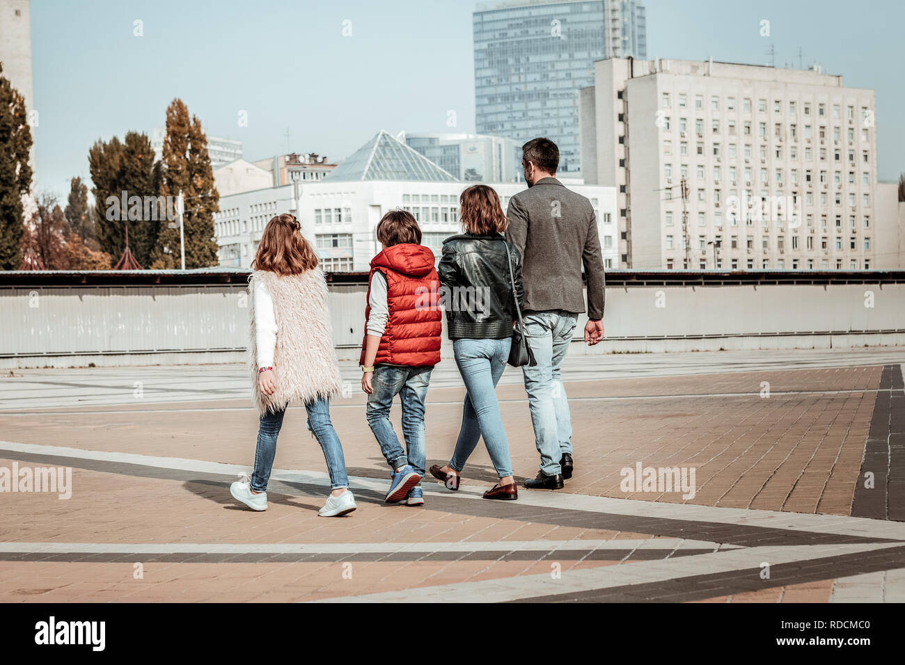 Active famiglia giovane a piedi al centro della città Foto Stock