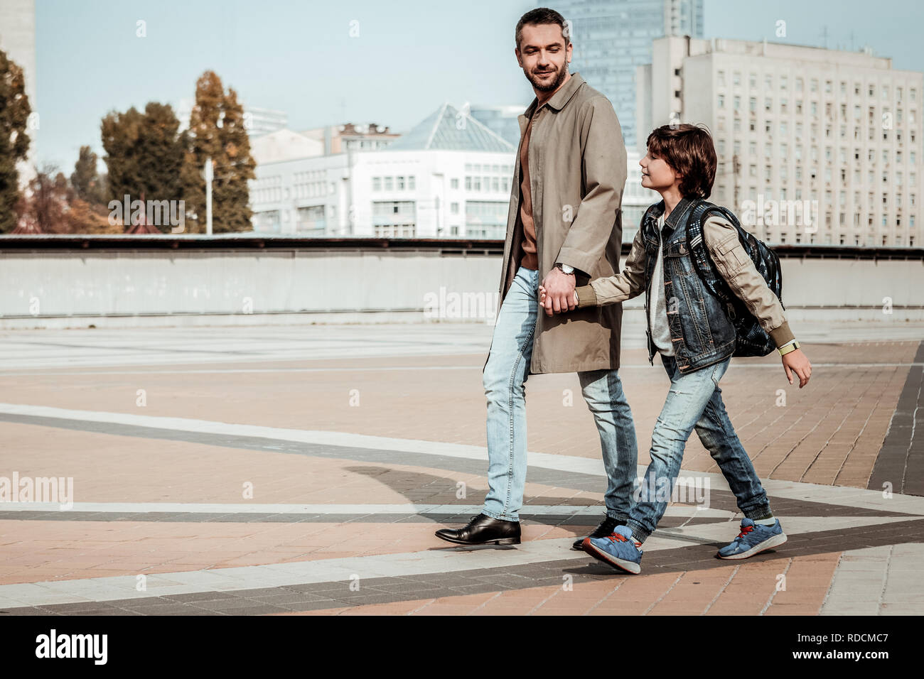 Padre andando mano nella mano con il suo figlio Foto Stock