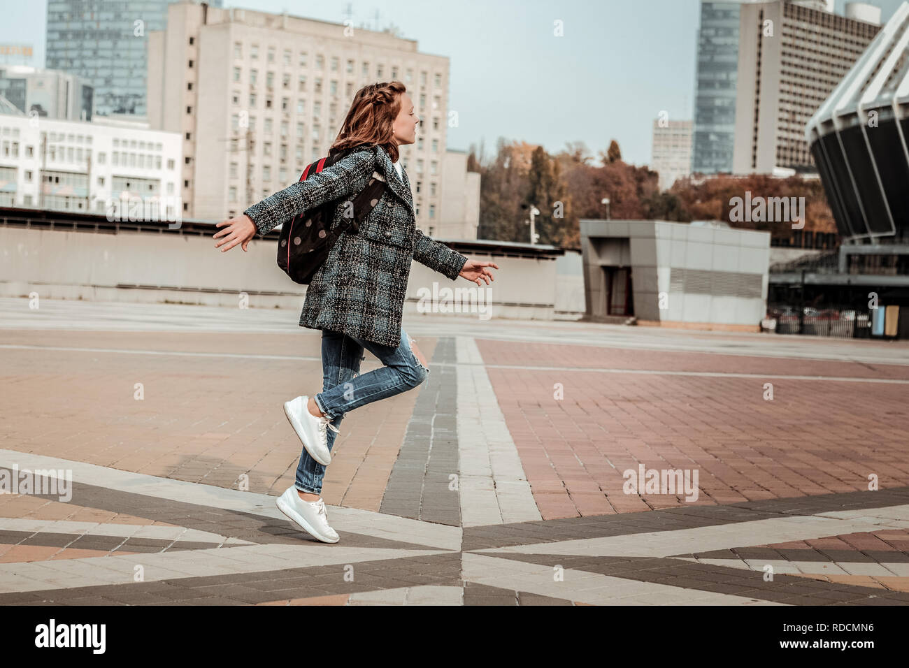 Felice ragazza saltando attraverso il centro della città Foto Stock