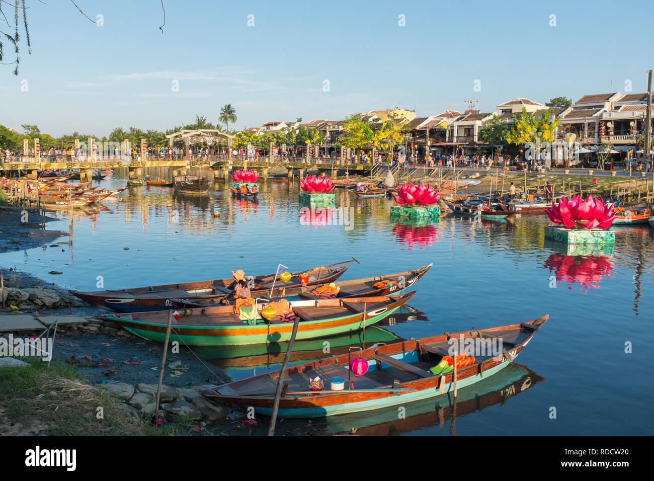 Piccole imbarcazioni in attesa di prendere i turisti per gite in barca sulle vie navigabili intorno alla città vietnamita di Hoi An in Quang Nam Provincia Foto Stock