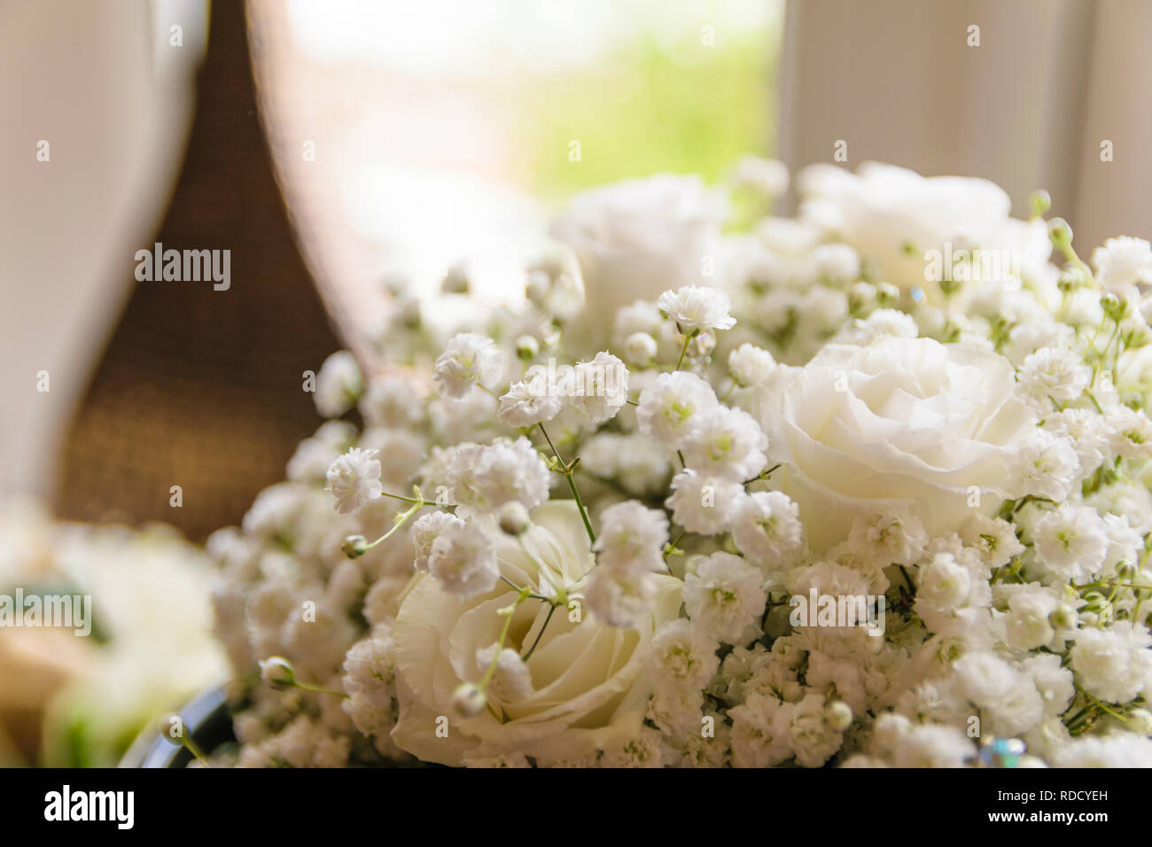 Un mazzo di fiori di nozze, il rose bianche splendenti nella luce solare attraverso la finestra. Foto Stock