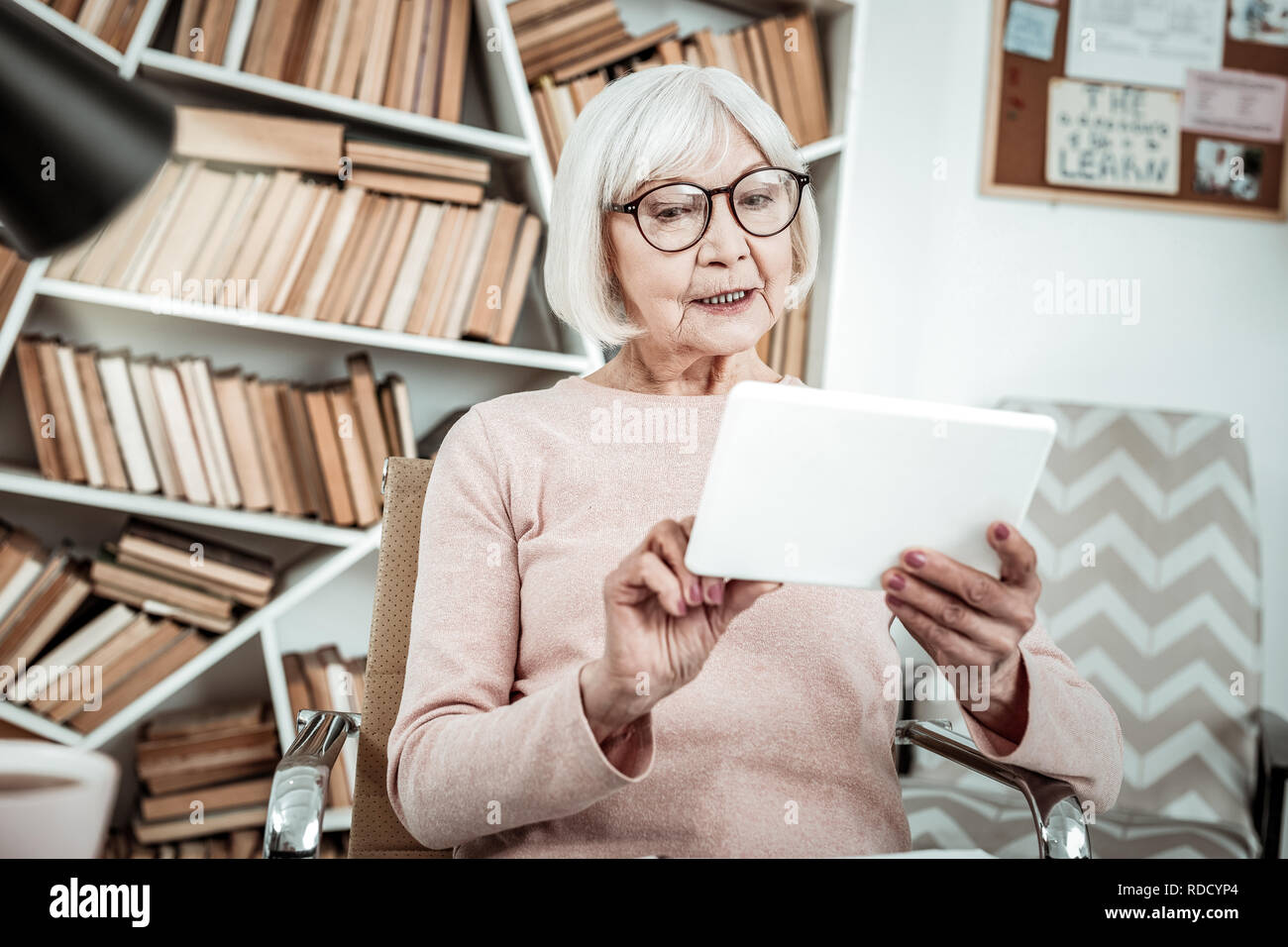 Attenta donna matura fissando il suo tablet Foto Stock