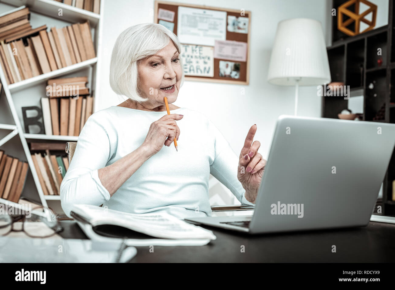 Creative femmina matura persona seduta al suo posto di lavoro Foto Stock
