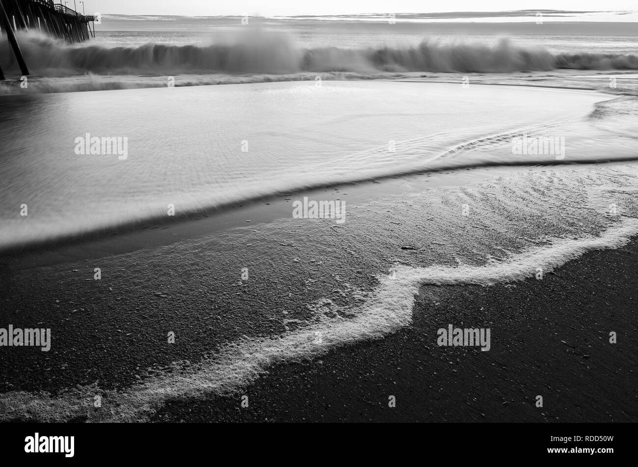 Immagine in bianco e nero di una rottura d'onda accanto al Virginia Beach molo di pesca Foto Stock