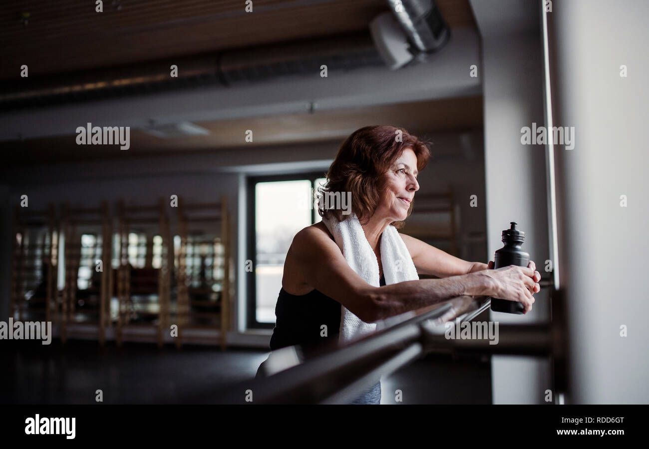 Un senior donna in palestra riposo dopo fare esercizio. Copia dello spazio. Foto Stock