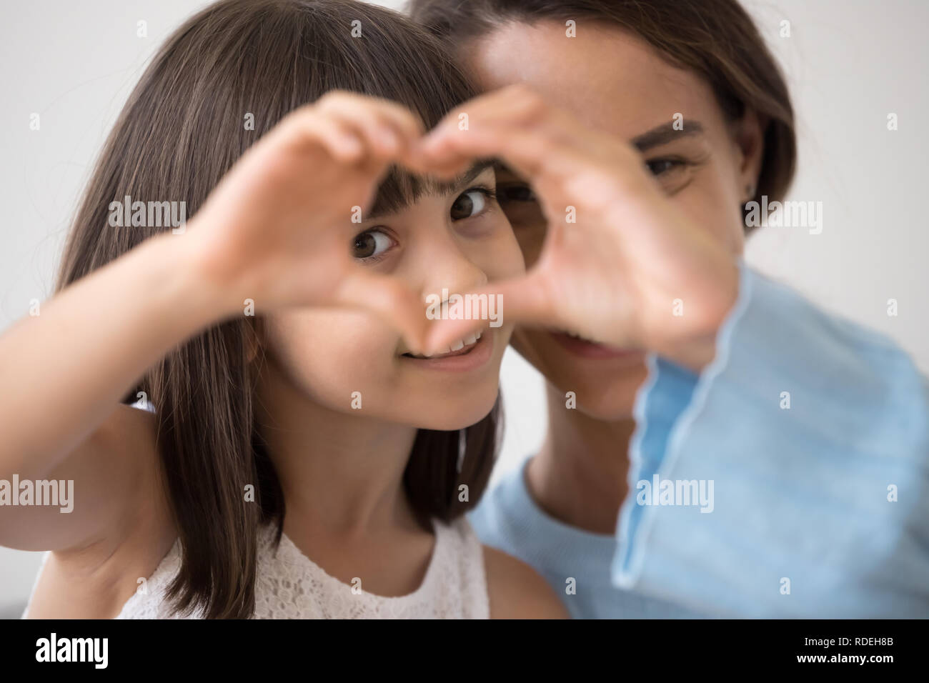 Ritratto di bambina e madre unire le mani formando cuore Foto Stock