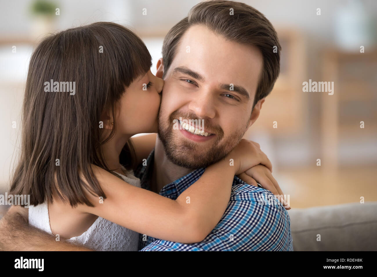 Carino kid figlia abbracciando kissing giovani felici papà sulla guancia Foto Stock