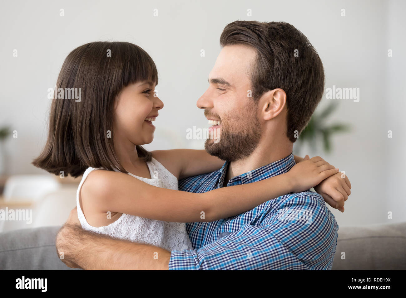 Carino kid ragazza ridere abbracciando il padre avendo divertimento con papà Foto Stock