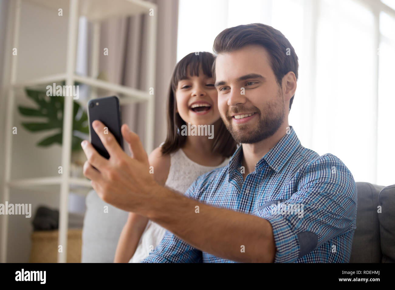 Padre sorridente tenendo selfie con cute kid figlia su smartphon Foto Stock