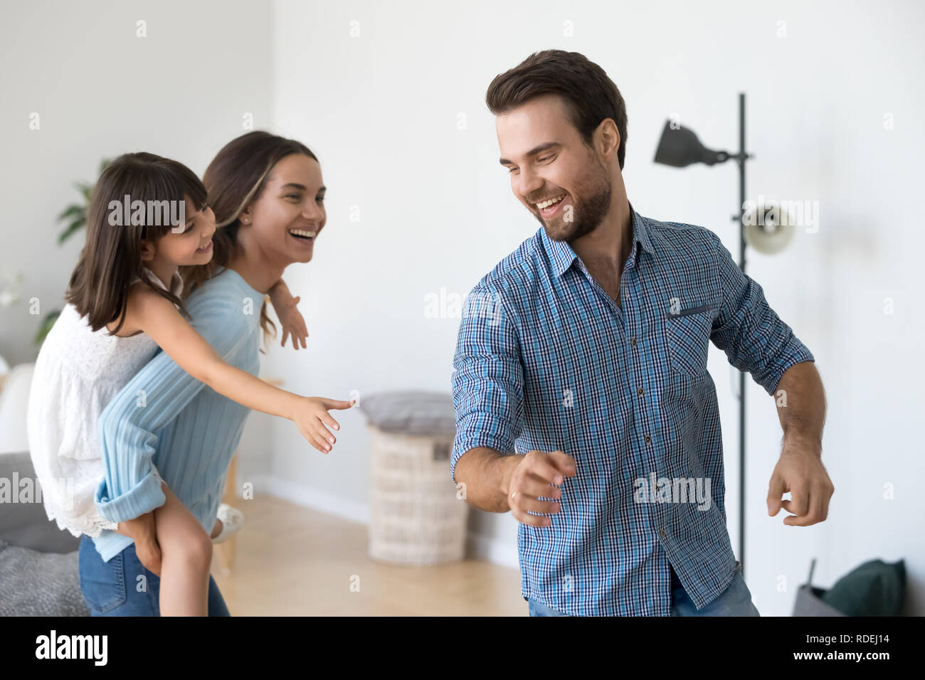 Felice la mamma che porta il bambino sul retro divertendosi la cattura di papà Foto Stock